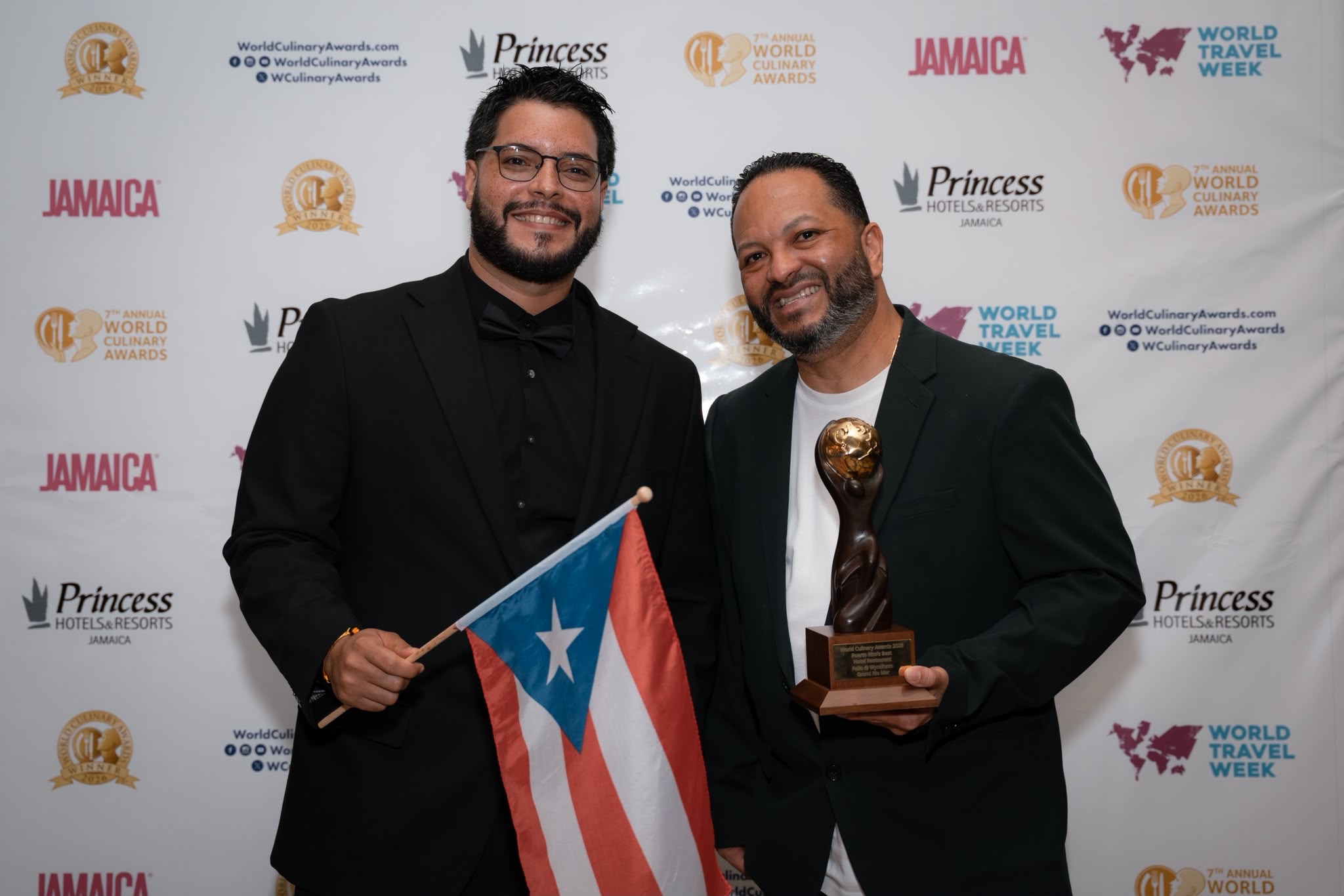 Chef Charles Davis and Executive Chef Ramón Carrillo celebrating with the Puerto Rico flag and Palio’s award